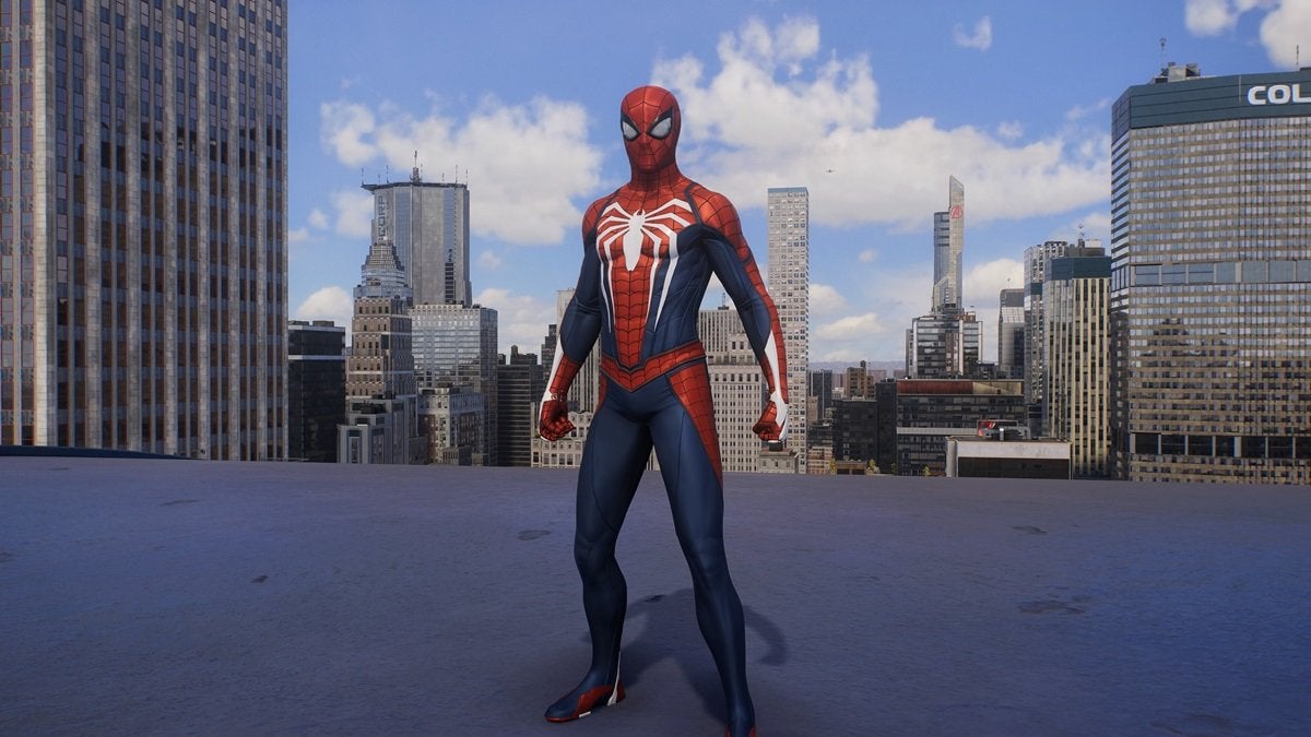 Peter Parker wearing the Advanced Suit, which is red and dark blue with a large white spider on the chest.