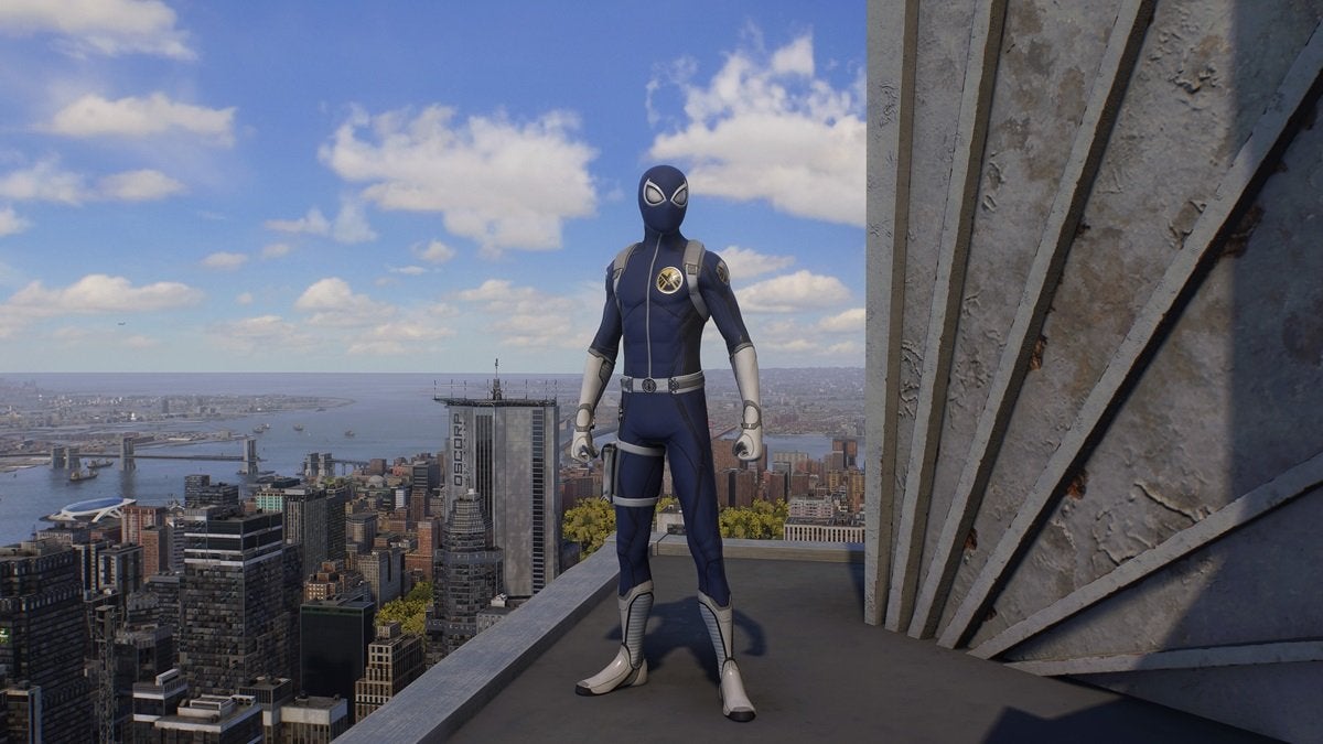 Miles Morales wearing the Agent of S.H.I.E.L.D, which is light gray and dark blue. There's a circular S.H.I.E.L.D. logo on the left side of the suit's chest.