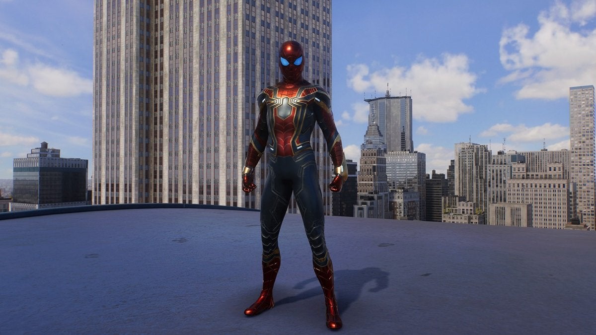 Peter Parker wearing the Iron Spider Suit, which is red, dark gray, and gold with a metallic sheen.