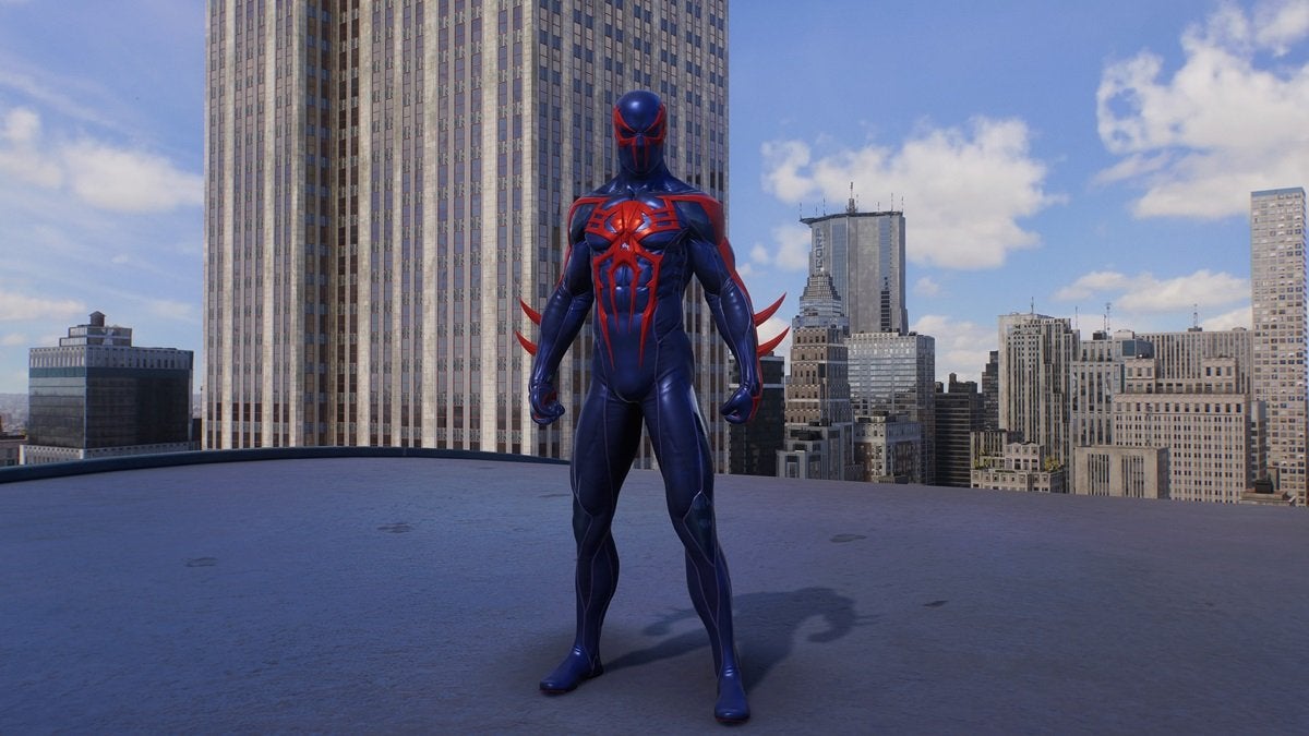 Peter Parker wearing the Spider-Man 2099 suit, which looks like the suit of the superhero Spawn. The suit is red and blue with red spikes coming out of the forearms and and evil-looking red spider on the chest. The eye pieces are also more aggressive and angular.