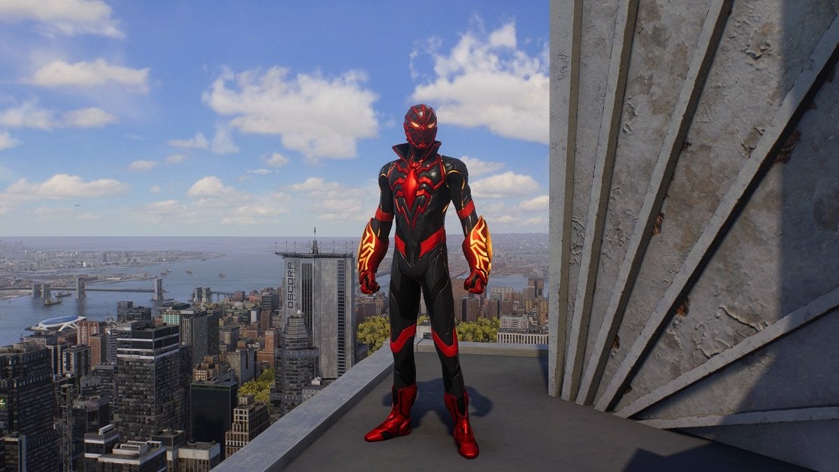 Miles Morales wearing the S.T.R.I.K.E. suit, which is red, black, and yellow. The collar of the suit is pointed and the forearms are armored with thick gauntlets.