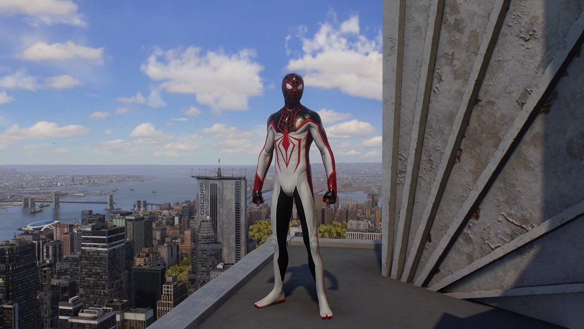 Miles Morales wearing the T.R.A.C.K. Suit, which is red, white, and black with a large red spider on the chest.