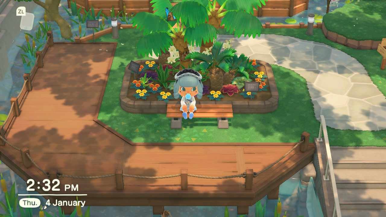 A player sitting inside the insectarium exhibit with a blue butterfly near the tree leaves above them.. 