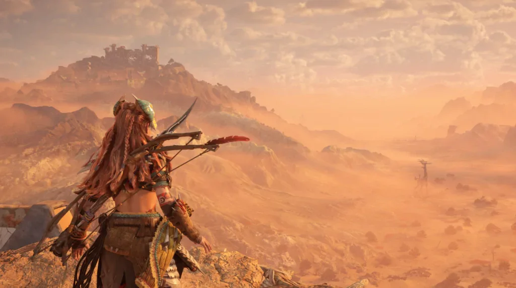 Aloy, the protagonist of Horizon Forbidden West (one of the games with the best story in modern times), looking over a desert valley with a Tallneck in the distance.