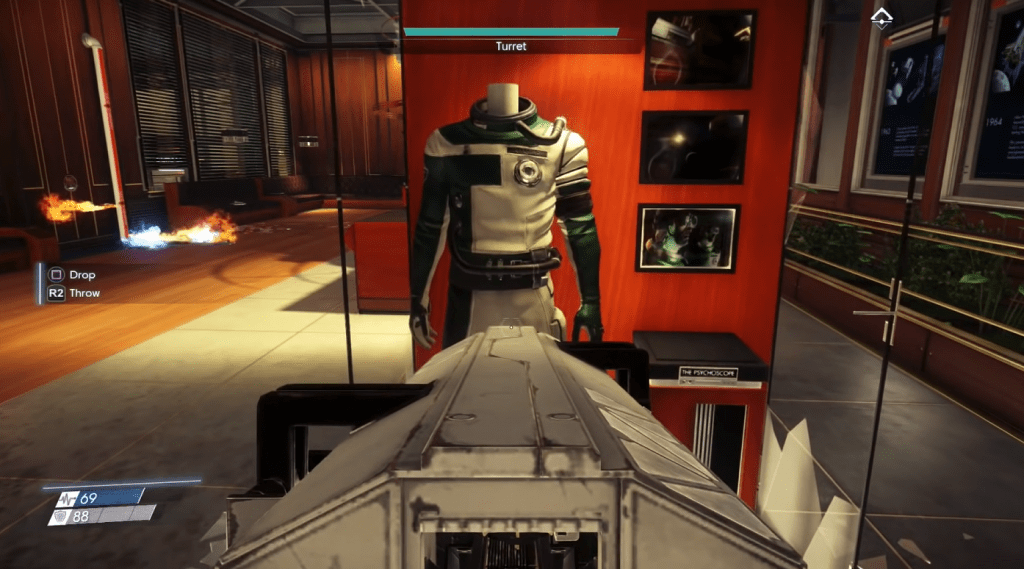 The main character of Prey pointing his gun at a uniform preserved in a glass case. 