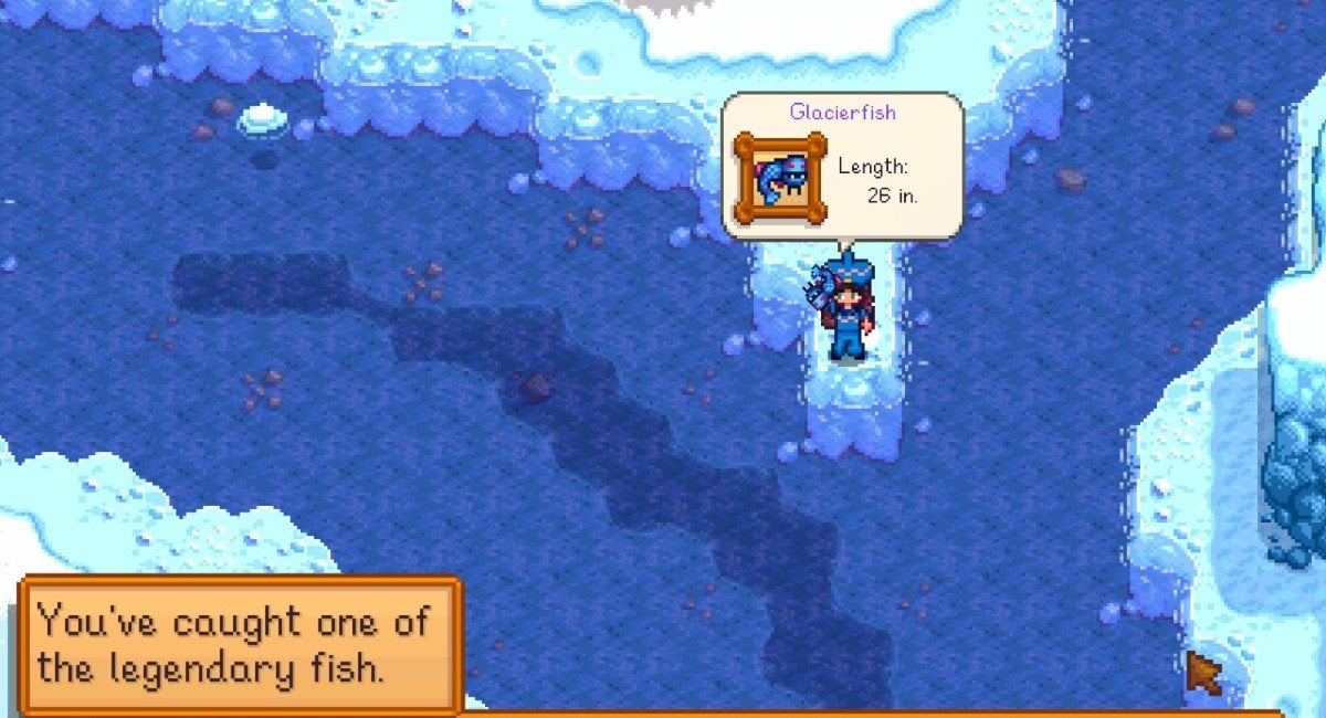 The player holding the blue and serpentine Glacierfish above their head after catching it.