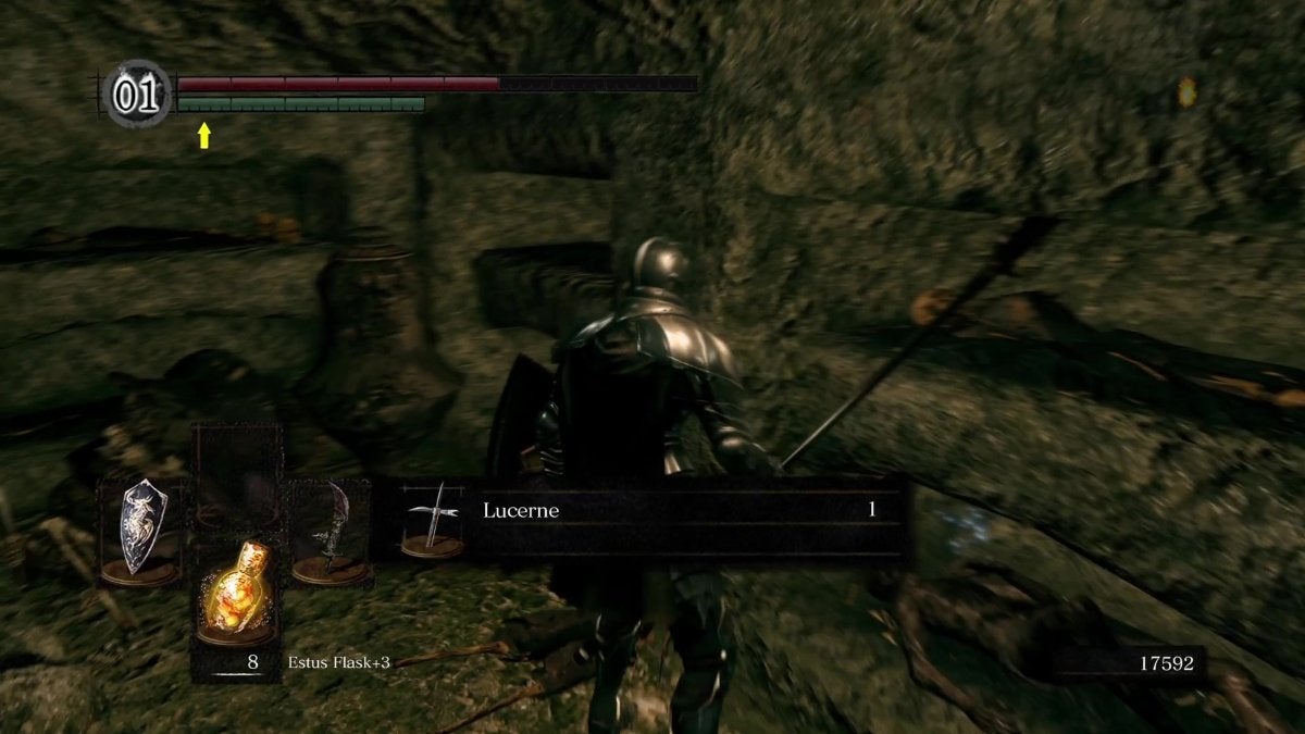The Chosen Undead picking up the Lucerne weapon in The Catacombs of Dark Souls.