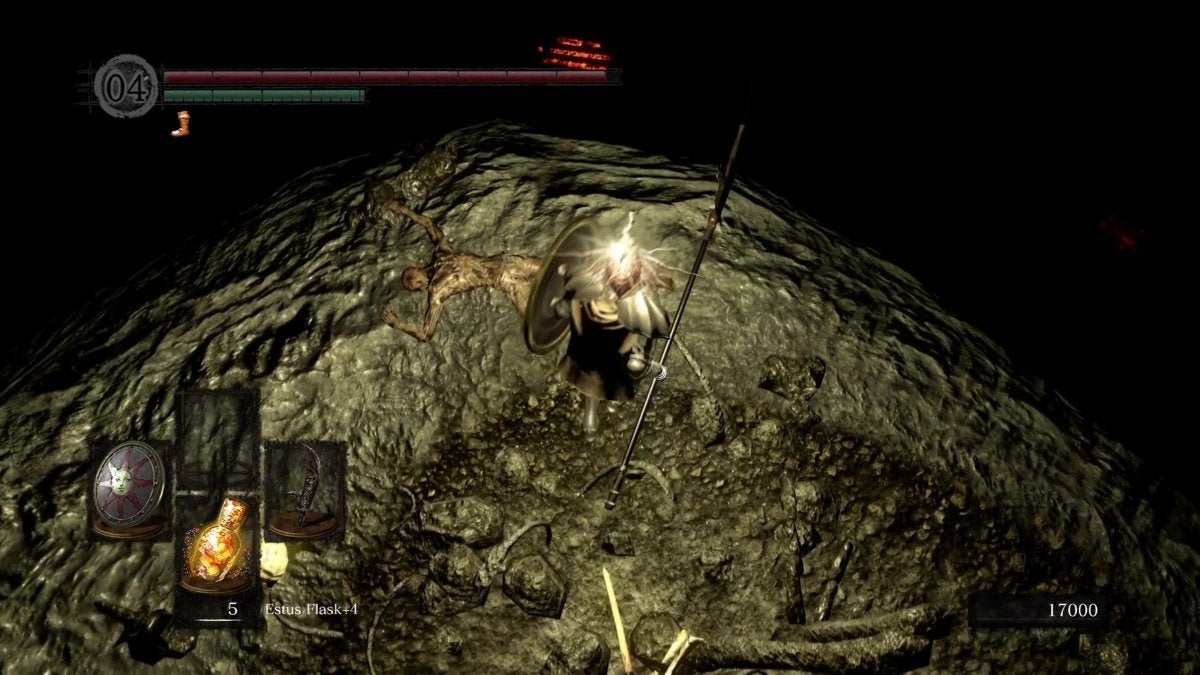 The Chosen Undead standing over a corpse in the Tomb of Giants.