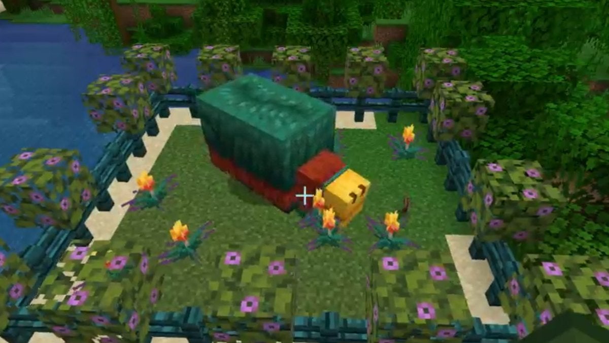 A Sniffer surrounded by Torchflowers in Minecraft.