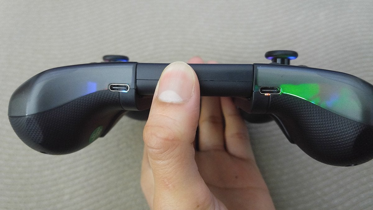 A hand holding up a Stellar T5 controller to show the two USB-C ports on the bottom.
