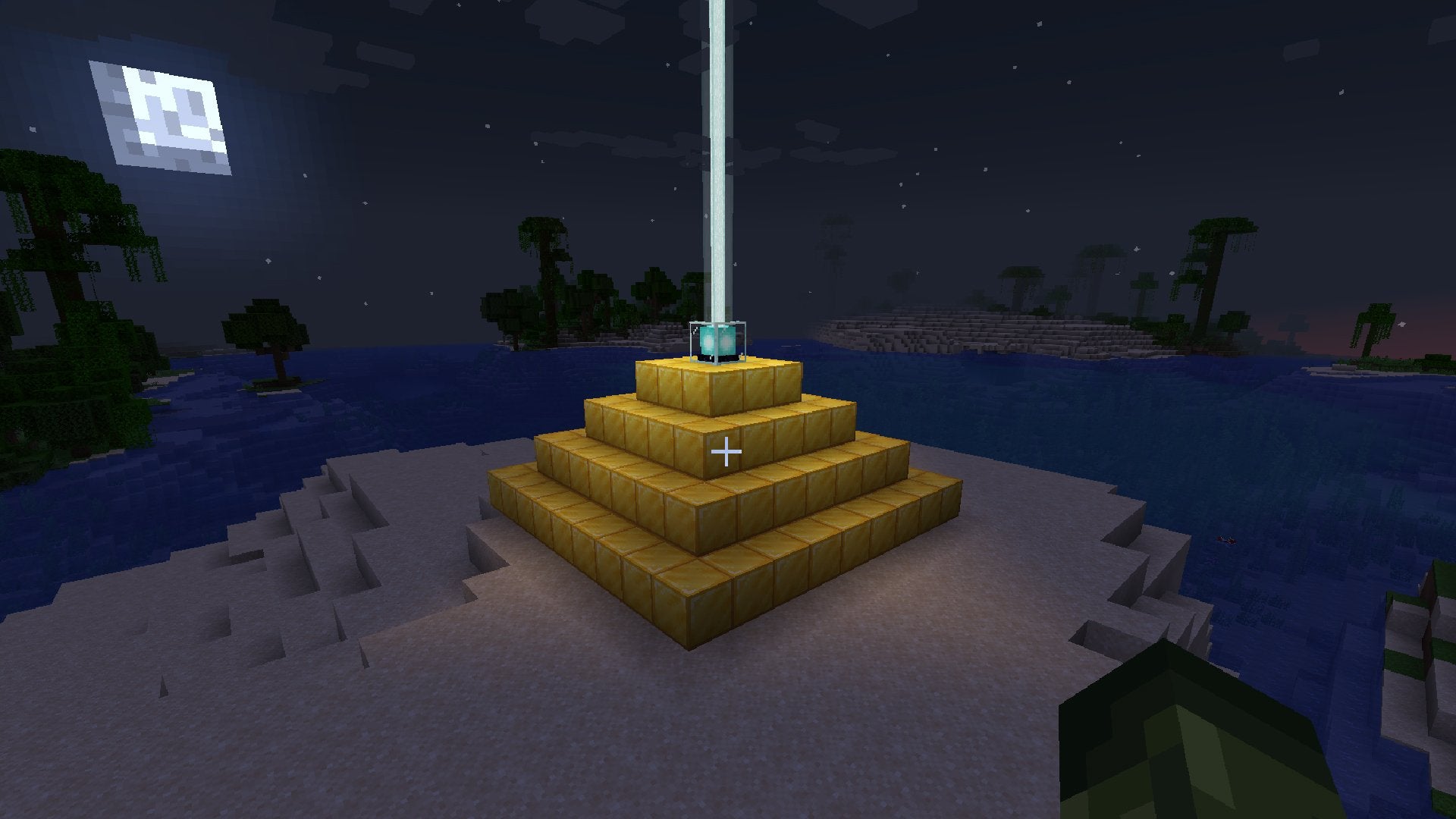 An active Beacon on top of a golden pyramid at night in Minecraft.